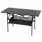 Black aluminum folding camping table with roll-up top and mesh storage basket