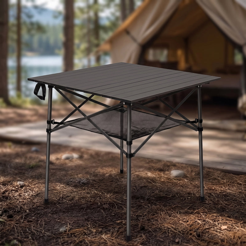 Black aluminum folding camping table with roll-up top and mesh storage basket