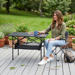 Woman setting drinks on an aluminum folding camping table outdoors
