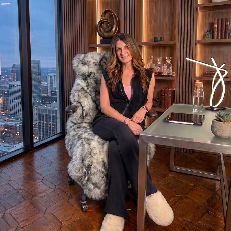Tan genuine sheepskin rug draped over a modern office chair in a high-rise workspace