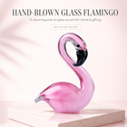 Hand-blown pink glass flamingo figurine with curved neck in sitting pose
