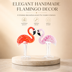 Hand-blown pink glass flamingo figurine with curved neck in sitting pose