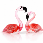 Hand-blown pink glass flamingo figurine with curved neck in sitting pose