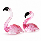 Hand-blown pink glass flamingo figurine with curved neck in sitting pose