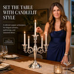 Gold candelabra with three lit taper candles on a styled formal dining table