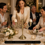 People gathered at a formal dinner table with a lit gold candelabra centerpiece