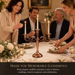 People gathered at a formal dinner table with a lit gold candelabra centerpiece