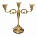 Gold three-arm metal candelabra candle holder on a white background
