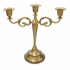 Gold three-arm metal candelabra candle holder on a white background