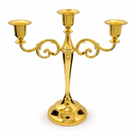 Gold three-arm metal candelabra candle holder on a white background