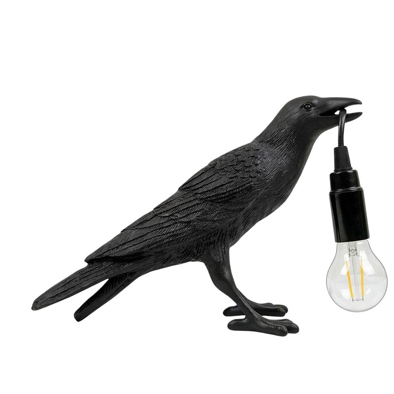 Black gothic raven lamp holding a hanging cord with a lit filament bulb on a white background