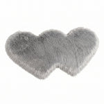 Rose red double attached heart shaped faux fur rug on a white background
