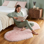 Pink heart shaped faux fur rug on a wood bedroom floor beside a bed