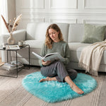 Pink heart shaped faux fur rug on a wood bedroom floor beside a bed