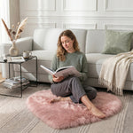 Pink heart shaped faux fur rug on a wood bedroom floor beside a bed