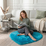 Pink heart shaped faux fur rug on a wood bedroom floor beside a bed