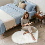 Pink heart shaped faux fur rug on a wood bedroom floor beside a bed