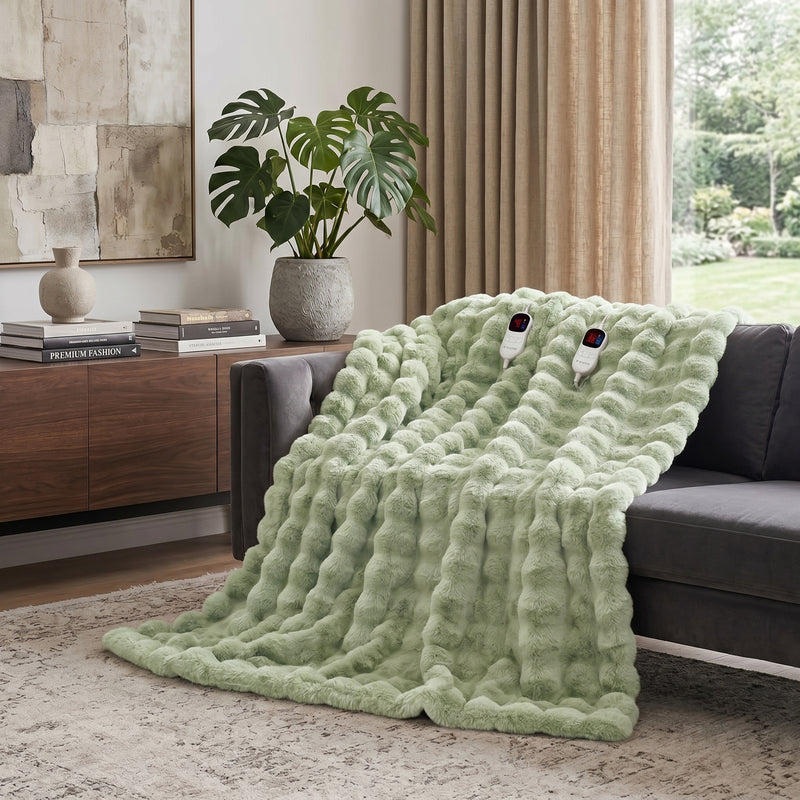 White faux rabbit fur heated blanket with bubble texture draped over a grey sofa in a modern living room