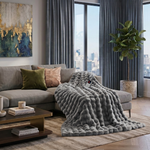 White faux rabbit fur heated blanket with bubble texture draped over a grey sofa in a modern living room