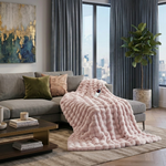 White faux rabbit fur heated blanket with bubble texture draped over a grey sofa in a modern living room