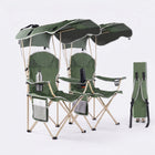 Black oversized folding camping chair with orange trim shown with two rolled carry bags on a white background