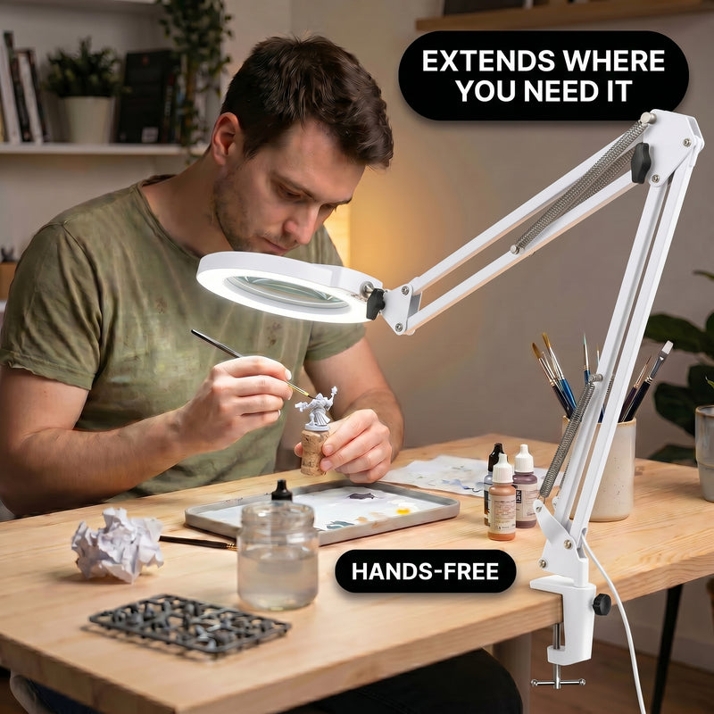Man using a clamp-mounted LED magnifying lamp to hand-paint a miniature figure at a hobby desk