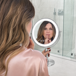 Woman applying makeup at a vanity table using the rechargeable LED makeup mirror