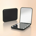 LED travel makeup mirror in pink, shown closed and open with LED lights on