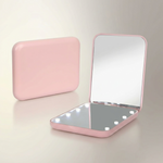 LED travel makeup mirror in pink, shown closed and open with LED lights on