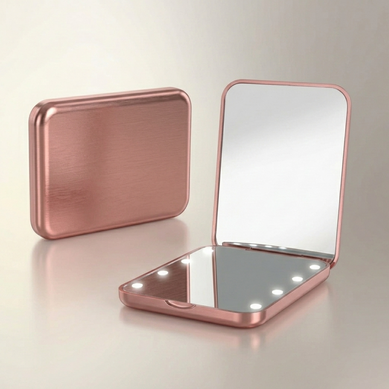 LED travel makeup mirror in pink, shown closed and open with LED lights on