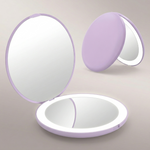 LED travel makeup mirror in pink, shown closed and open with LED lights on