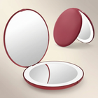 LED travel makeup mirror in pink, shown closed and open with LED lights on