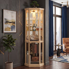 Oak lighted corner curio cabinet displaying crystal and glassware in a living-room corner