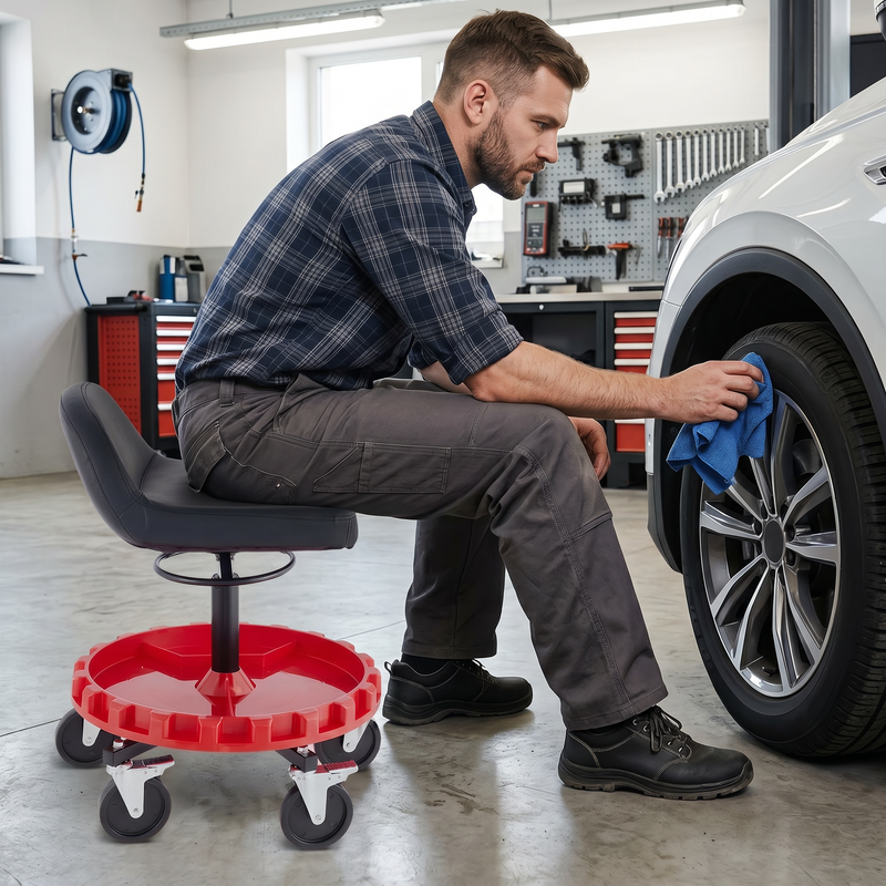 Person detailing a grey car beside the rolling mechanic stool with five swivel casters