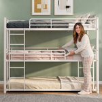Adult standing beside a black metal bunk bed showing its full-size scale