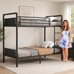 Adult standing beside a black metal bunk bed showing its full-size scale