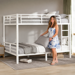 Adult standing beside a black metal bunk bed showing its full-size scale