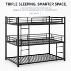 Black full-over-full metal bunk bed with ladder and guardrails in a styled bedroom
