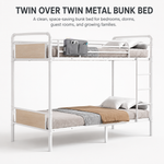 Black full-over-full metal bunk bed with ladder and guardrails in a styled bedroom