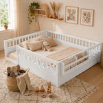 Natural wood Montessori floor bed with fence rails styled in a child's room