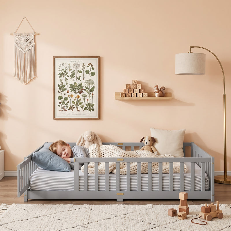 Toddler resting on a natural Montessori floor bed with fence in a forest-themed nursery