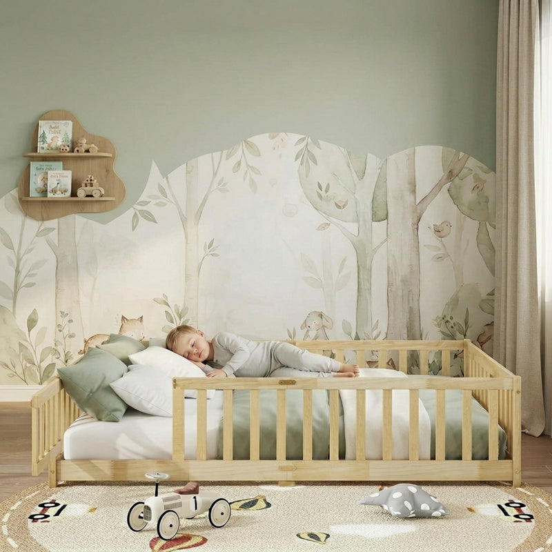 Toddler resting on a natural Montessori floor bed with fence in a forest-themed nursery