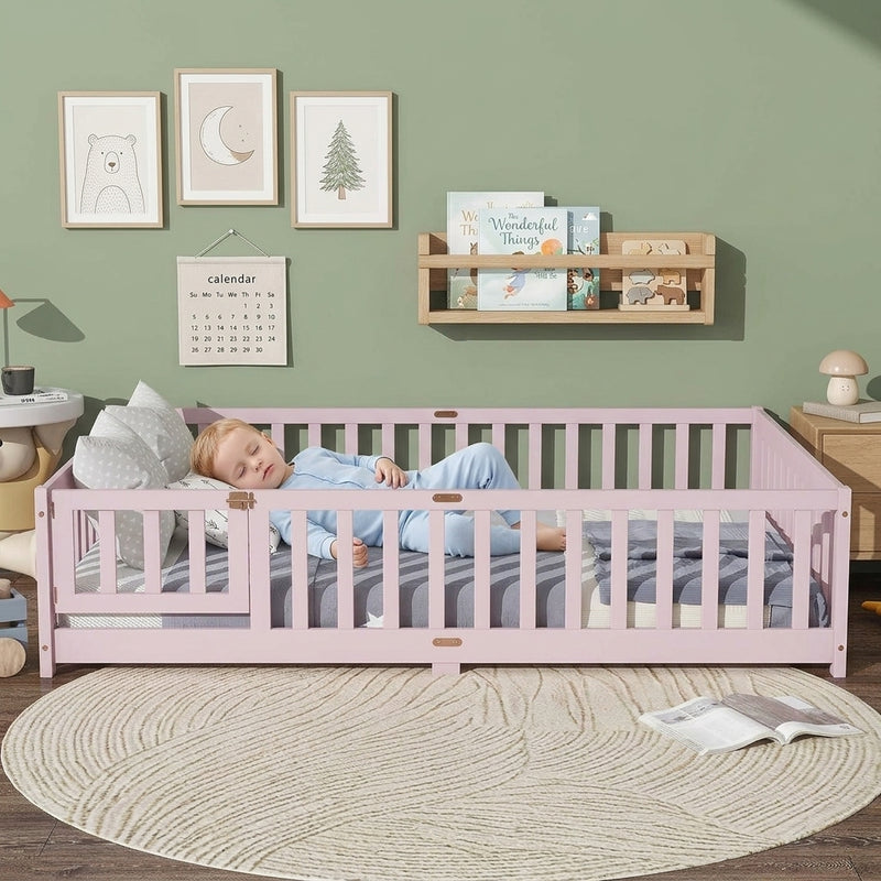 Toddler resting on a natural Montessori floor bed with fence in a forest-themed nursery