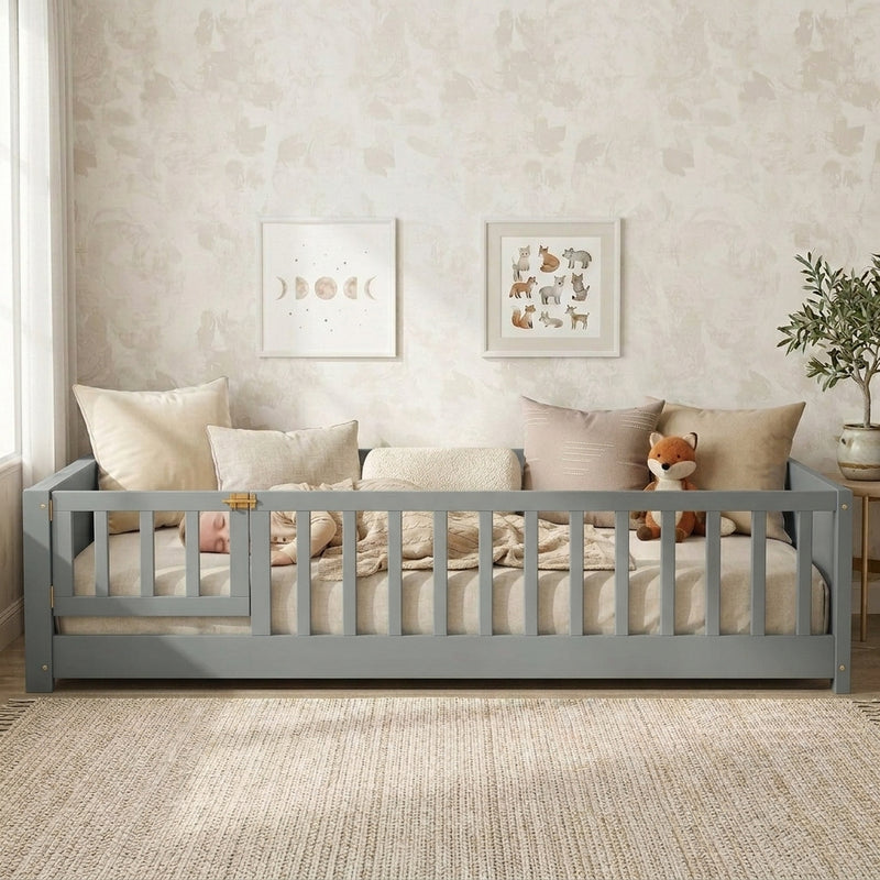 Toddler resting on a natural Montessori floor bed with fence in a forest-themed nursery