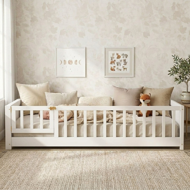 Toddler resting on a natural Montessori floor bed with fence in a forest-themed nursery