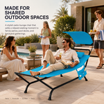 Man relaxing on a navy outdoor chaise lounger with canopy at a poolside gathering