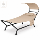 Navy outdoor chaise lounger with canopy, cushion and headrest pillow on a patio