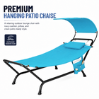 Navy outdoor chaise lounger with canopy, cushion and headrest pillow on a patio