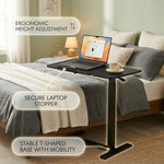 White overbed table with wheels positioned next to bed in bedroom setting