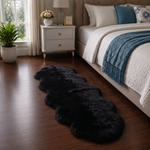 Real sheepskin rug in tan placed beside a bed on dark hardwood floor in a bedroom setting